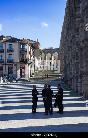 Hommes parlant dans la rue à l'aqueduc de Segovia, Espagne Banque D'Images