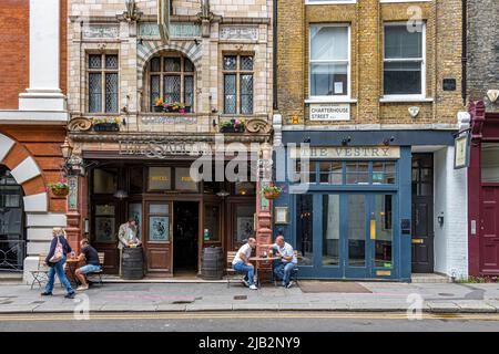 Les gens à l'extérieur en prenant un verre au pub Fox & Anchor sur Charterhouse St , Farringdon , Londres EC1 Banque D'Images