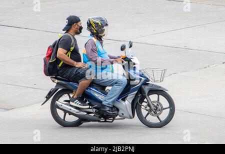 SAMUT PRAKAN, THAÏLANDE, MAI 06 2022, Un chauffeur de taxi sur une moto se déplace avec un homme. Le moto-taxi transporte un passager Banque D'Images