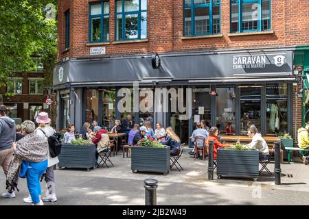 Les gens assis à l'extérieur de Caravan un café, restaurant et bar situé sur Exmouth Market, Clerkenwell, Londres EC1 Banque D'Images
