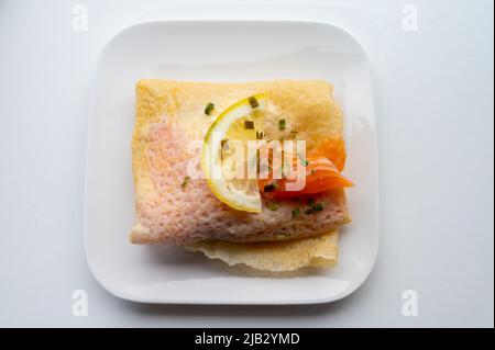 Cuisine de Normandie, galette de crêpes fourrée de fromage de chèvre et saumon fumé servie avec du citron frais, France Banque D'Images