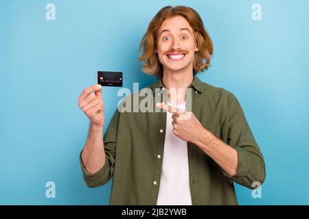 Portrait de sympathique funky gai gars démontrant carte bancaire nfc cash back isolé sur fond bleu pastel Banque D'Images