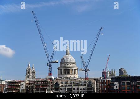 La cathédrale Saint-Paul est entourée de deux grues de chantier par une journée ensoleillée. Banque D'Images