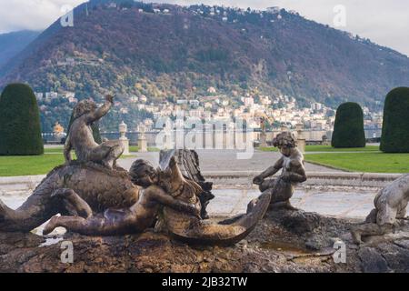 Côme, Italie, novembre 2021. Fontaine dans le parc Villa Olmo. Sculpture, deux enfants jouant avec un monstre marin. Fontaine et éclaboussures d'eau sur un blurr Banque D'Images