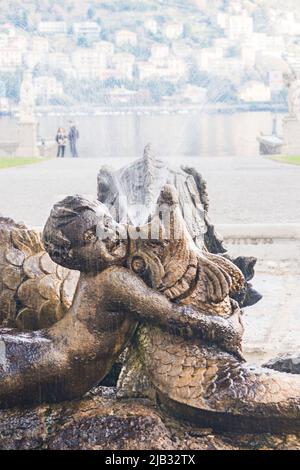 Côme, Italie, novembre 2021. Fontaine dans le parc Villa Olmo. Sculpture, deux enfants jouant avec un monstre marin. Fontaine et éclaboussures d'eau sur un blurr Banque D'Images