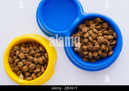 vue de dessus des bols avec eau et nourriture pour animaux sur blanc Banque D'Images