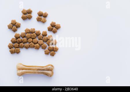 vue de dessus de la patte en forme de nourriture sèche pour animaux près de l'os isolé sur blanc Banque D'Images