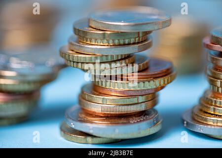 Ils ont accumulé des pièces en euros dans les tours. Pièces sur fond bleu. Devise EUR de l'Union européenne Banque D'Images