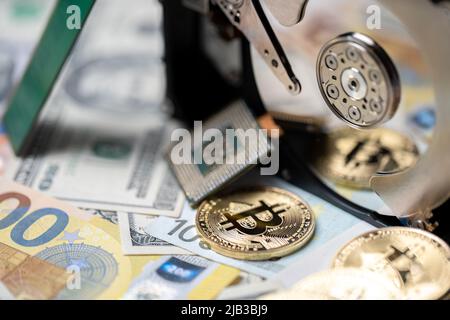 Bitcoin réfléchissant sur le plateau du disque dur à côté du processeur et sur les billets en euros et en dollars. Concept d'exploitation minière de crypto-monnaie, technologie blockchain. Banque D'Images