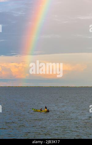 Un bateau de pêche local et un arc-en-ciel dans l'après-midi au-dessus du lac Tonle SAP dans le système du Mékong, province de Siem Riep / Pursat, nord-ouest du Cambodge Banque D'Images