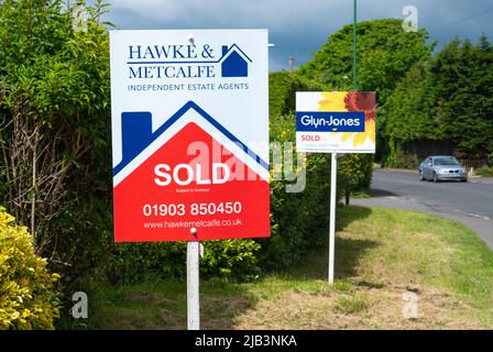 Signature de l'agent immobilier (Hawke & Metcalfe) et une autre pour les agents immobiliers Glyn Jones montrant des maisons ou des propriétés vendues. Affiche maison vendue en Angleterre, Royaume-Uni. Banque D'Images