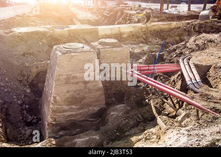 Trappes et puits d'égout dans une tranchée creusée par des excavateurs pendant la réparation, le drainage. Banque D'Images