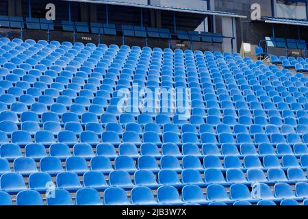 Sièges en plastique bleu sur la tribune ouverte du stade sportif. Un endroit pour la presse Banque D'Images