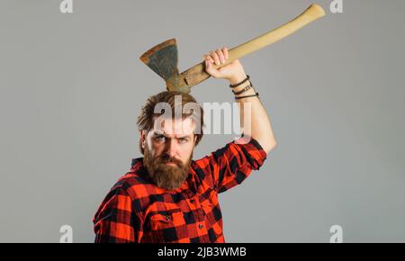 Homme barbu en chemise à carreaux avec hache. Outils de l'enregistreur. Coupe du bois. Bûcheron canadien avec hachet. Banque D'Images