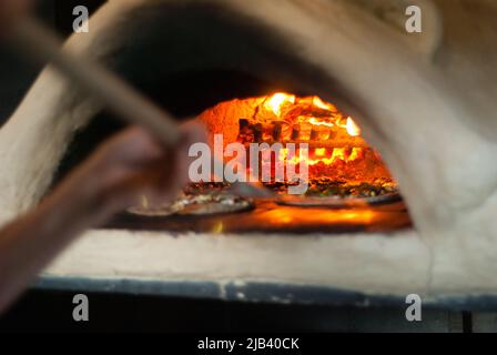 Four à pizza au feu de bois avec feu chaud Banque D'Images