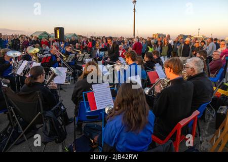 Hove Promenade, Hove Lagoon, ville de Brighton et Hove, East Sussex, Royaume-Uni. Halte à la balise Hove célébrant les célébrations du Jubilé de platine de la reine Elizabeth II. La balise était allumée avec un écran LED spécialement conçu par l'artiste local Eleni Shiarlis. Il s'agit d'un affichage permanent allumé tous les soirs. Dans cette photo est de la bande locale de laiton de Hangleton se présentant devant des centaines de résidents locaux. 2nd juin 2022. David Smith/Alamy News Banque D'Images