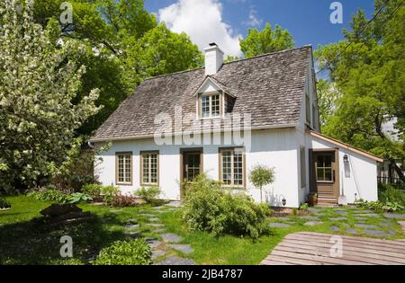 Ancienne maison de style caniana vers 1886 avec revêtement en stuc blanc et toit en bardeaux en cèdre au printemps. Banque D'Images