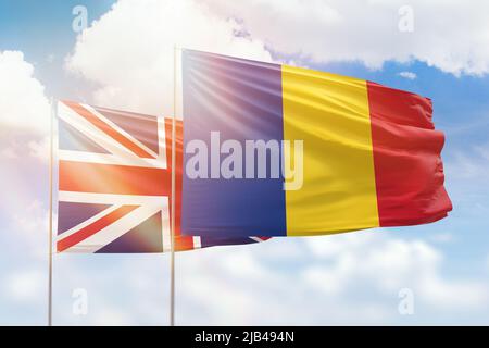 Ciel bleu ensoleillé et drapeaux de la roumanie et du royaume-uni Banque D'Images