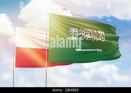 Ciel bleu ensoleillé et drapeaux de l'arabie saoudite et de la pologne Banque D'Images