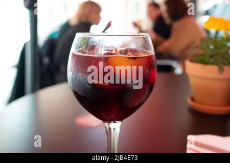 délicieux sangria rouge avec des morceaux d'oranges dans le verre à vin. Arrière-plan flou dans une barre Banque D'Images