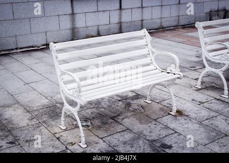 Vieux bancs blancs sur le trottoir Banque D'Images