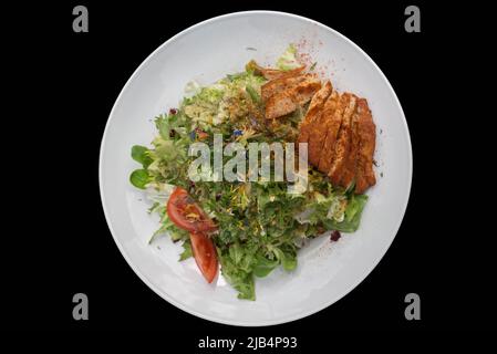 Salade mixte avec lanières de dinde rôties sur une base noire, Bavière, Allemagne Banque D'Images