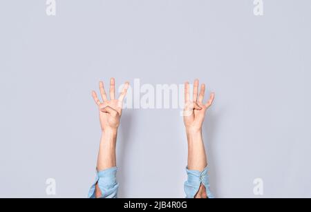 Les mains d'homme comptant quatre, les doigts comptant quatre, les doigts de main comptant quatre sur un arrière-plan isolé, compte à rebours Banque D'Images