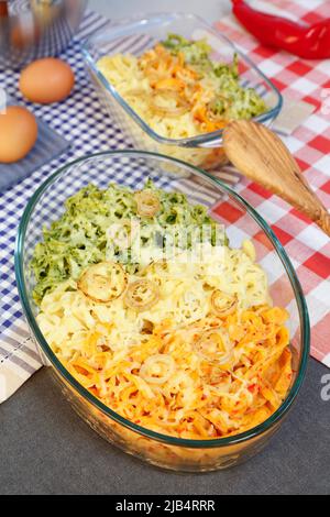 Cuisine souabe, cassolette spaetzle, trois types de spaetzle cuits au fromage, spaetzle classique, aux épinards et aux poivrons rouges, oignon fondu Banque D'Images