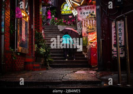 Jiufen, Taiwan - décembre 18 2019 : les femmes avec son enfant marchant dans la petite allée de Jiufen Shopping Street en jours de pluie. Banque D'Images