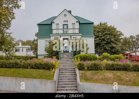 Vue d'une route publique à Akureyri vers quelques maisons typiques de la région, vieille ville villa faite en 1928 sur une journée nuageux. Banque D'Images