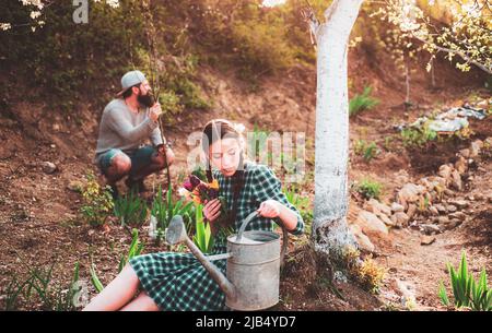 Couple de jardiniers avec outils de jardin. Amis travaillant dans le jardin. Jardinage agriculture et concept de personnes. Banque D'Images