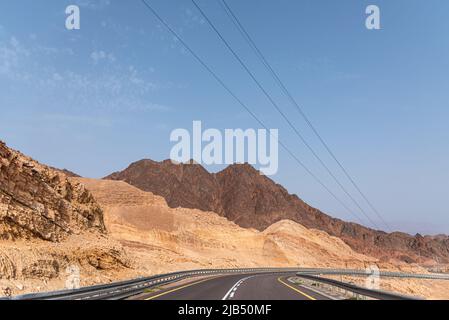 Une route à côté d'un paysage montagneux désertique. Route 12 sur le chemin d'Eilat, Israël, à la frontière égyptienne. Montagnes dans différentes couleurs de sable. Photo de haute qualité Banque D'Images