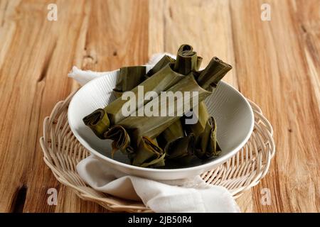 Lontong est un plat indonésien. Le riz est roulé à l'intérieur d'une feuille de banane et bouilli, puis coupé en petits gâteaux comme aliment de base de remplacement du riz vapeur. Banque D'Images