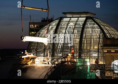 Dresde, Allemagne. 02nd juin 2022. Un rouleau de membrane en fibre de verre est soulevé sur le toit de la gare centrale de Dresde par une grue à chenilles. Le rouleau de 700 kg est un matériau pour le renouvellement du toit de la salle de football de terrain autour du dôme en verre de la station. Credit: Sebastian Kahnert/dpa/Alay Live News Banque D'Images