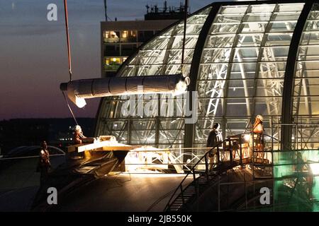 Dresde, Allemagne. 02nd juin 2022. Un rouleau de membrane en fibre de verre est soulevé sur le toit de la gare centrale de Dresde par une grue à chenilles. Le rouleau de 700 kg est un matériau pour le renouvellement du toit de la salle de football de terrain autour du dôme en verre de la station. Credit: Sebastian Kahnert/dpa/Alay Live News Banque D'Images