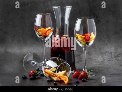 Verre de Sangria rouge et fruits sur table en pierre sombre Banque D'Images