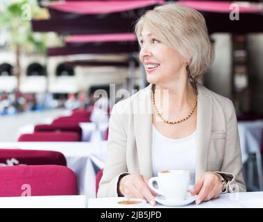 Portrait d'une femme mûre élégante qui profite du déjeuner avec un café Banque D'Images