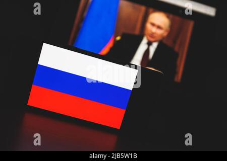 Le drapeau russe et le président russe Vladimir Poutine en arrière-plan à la télévision Banque D'Images