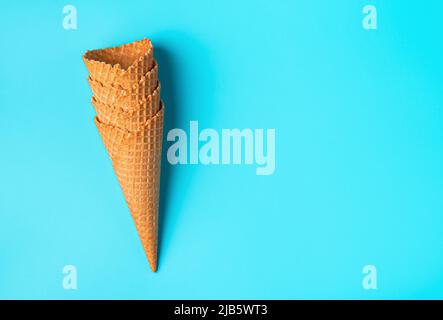 Tasses de glace gaufrées empilées sur un fond bleu. Banque D'Images
