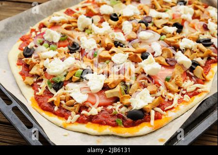 Pizza crue al funghi avec chanterelle champignons et olives sur papier à pâtisserie horizontal Banque D'Images