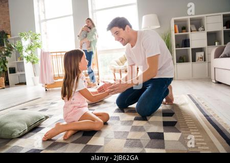 Photo de drôle doux mari femme petits enfants père jouant patty gâteau jeu sourire à l'intérieur chambre maison Banque D'Images