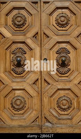 Anciennes portes en bois massif ornées de décorations sculptées à la main par des artistes locaux, dans le splendide centre historique de Lucques Banque D'Images