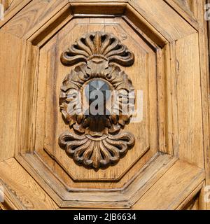 Anciennes portes en bois massif ornées de décorations sculptées à la main par des artistes locaux, dans le splendide centre historique de Lucques Banque D'Images