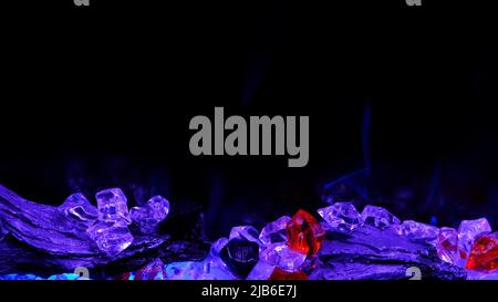 vue sur cheminée électrique avec flamme artificielle étincelante, décor pour l'intérieur, flamme bleue sur cristaux. Banque D'Images