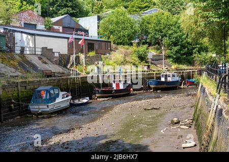 Petits bateaux amarrés à marée basse dans la rivière Ouseburn, Newcastle upon Tyne, Royaume-Uni. Banque D'Images