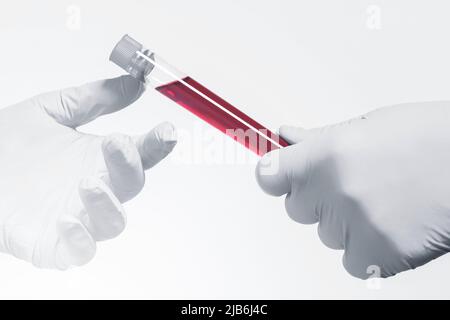 Vacutainer d'échantillon de sang et de la main du scientifique portant des gants en latex. Concept de tests sanguins ou de recherche. Banque D'Images