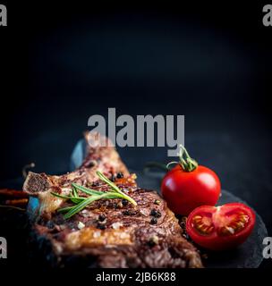 Steak de bœuf grillé sur os avec tomates Banque D'Images