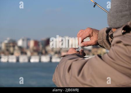 Le pêcheur prend un poisson d'un crochet de pêche avec un fond de bokeh. Banque D'Images