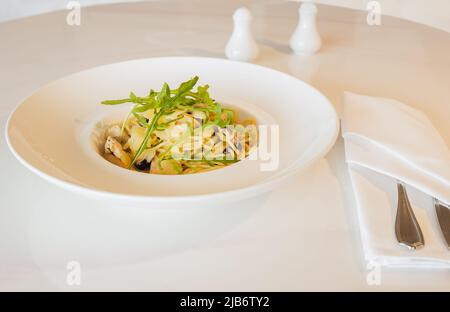 Spaghetti aux pâtes avec sauce à la crème de champignons aux truffes dans une assiette blanche. Banque D'Images