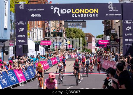 Cyclistes du peloton traversant la ligne d'arrivée à Maldon High Street à la course cycliste RideLondon Classique, étape 1, Essex, Royaume-Uni Banque D'Images